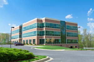 Suburban Maryland commercial office building with an asphalt parking lot and access drive, the type of property PotholeRepair.com scopes for commercial asphalt repair