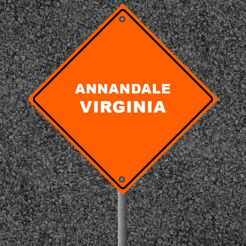 Orange warning sign displaying "Annandale Virginia" against a textured asphalt background, highlighting the commercial area relevant to local asphalt and pothole repair services.