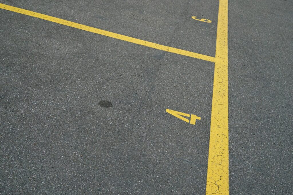 Commercial parking lot in Northern Virginia with numbered stalls and early asphalt cracking