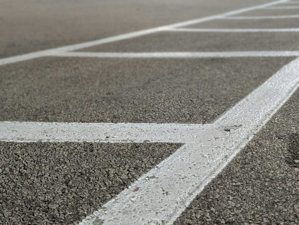 Close up of freshly painted parking space lines on well maintained commercial asphalt