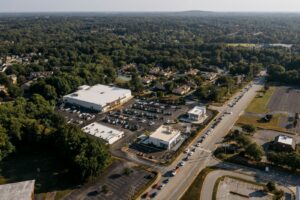 Aerial view of a multi-site commercial property portfolio, showing retail, office, and restaurant lots side by side near a residential neighborhood